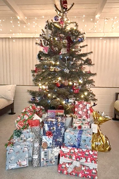 Wrapped gifts under a holiday tree.
